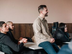 Преподавател се усмихва и разговаря с ученици